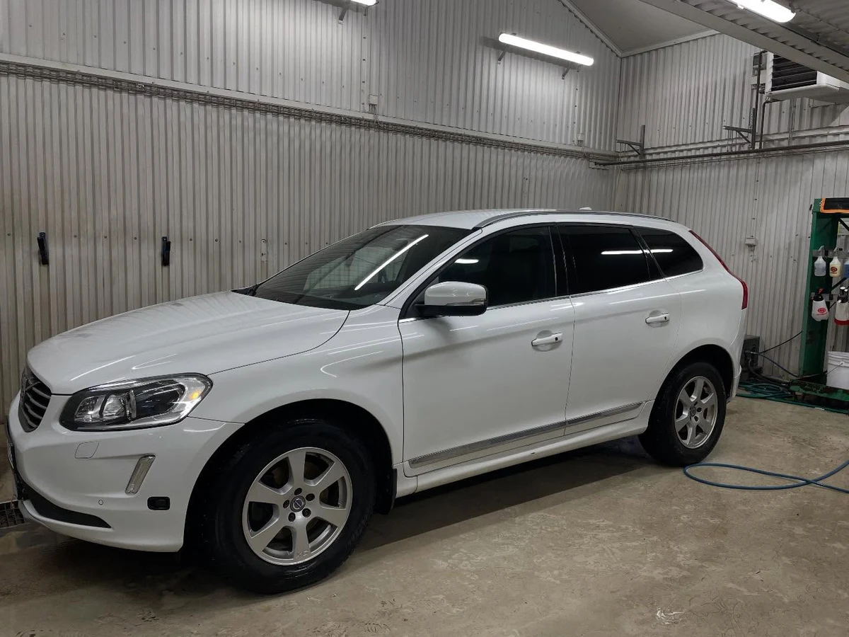 Vit Volvo XC60 efter rekond, fotograferad snett framifrån